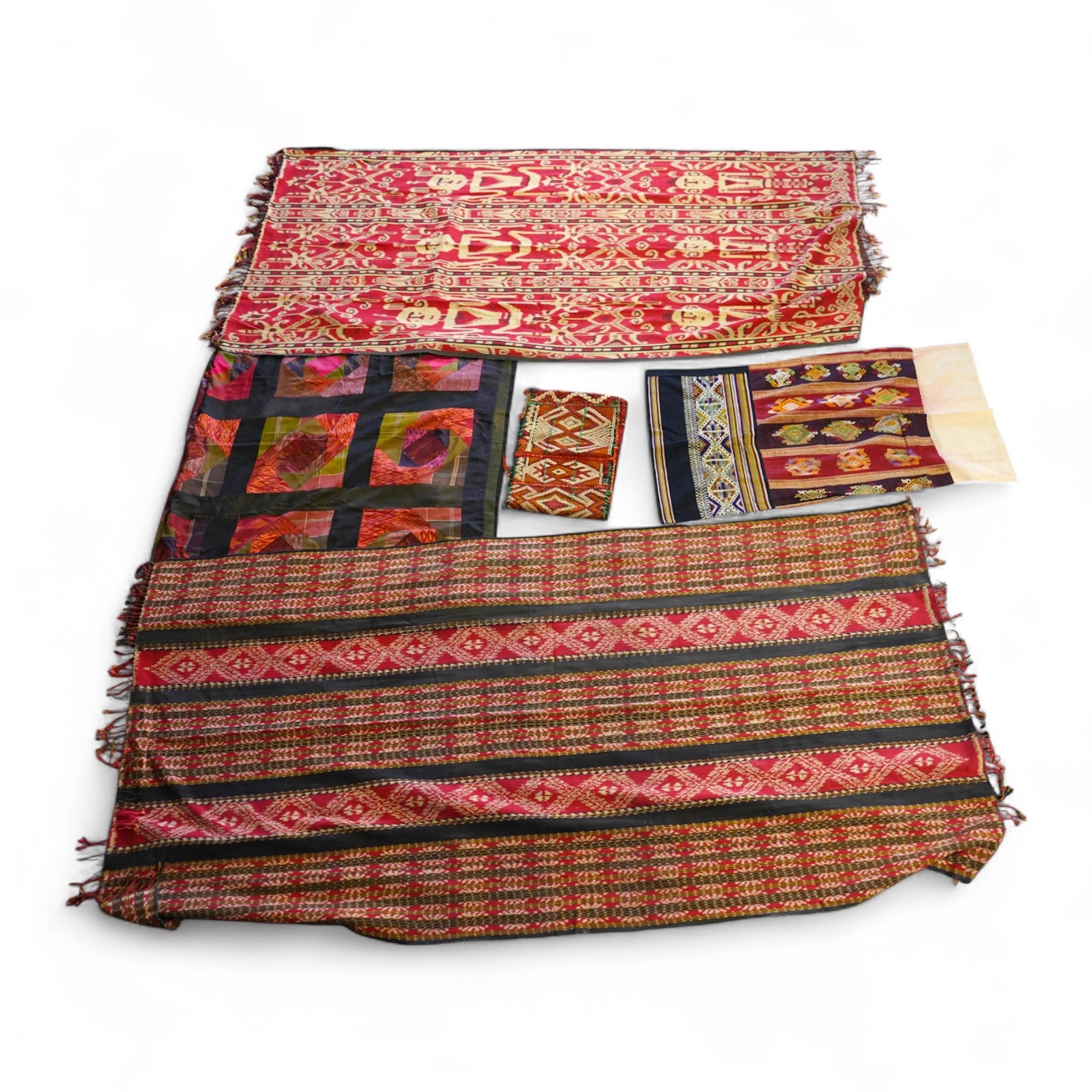 A 20th century Indonesian Sumba single Ikat shoulder cloth, a similar Celebes cloth, a Berber woven skirt and saddle bag and a patchwork cover. (5). Skirt 110cm including hessian top., Condition - some patchwork in the c